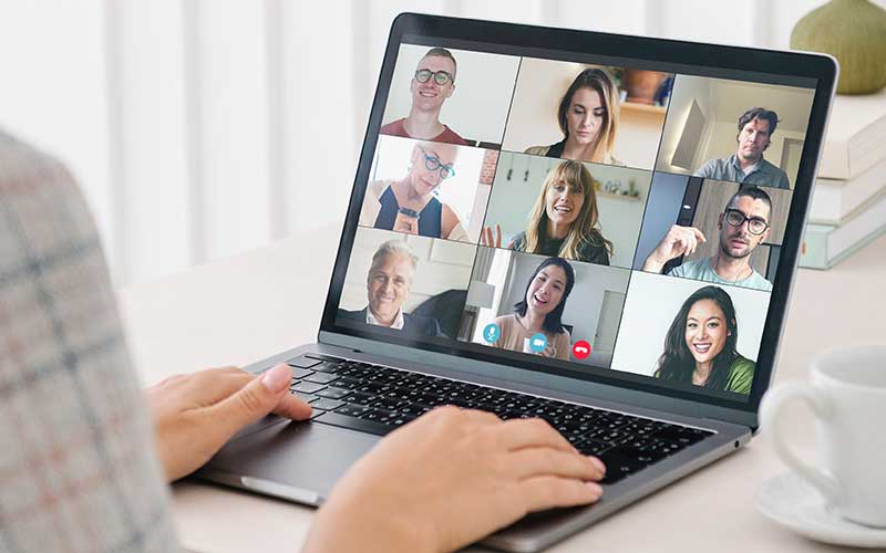 A person on a video chat via laptop, connecting with others in a virtual conversation.